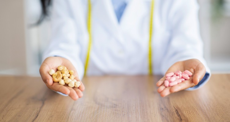 A person holding different pills in each hand