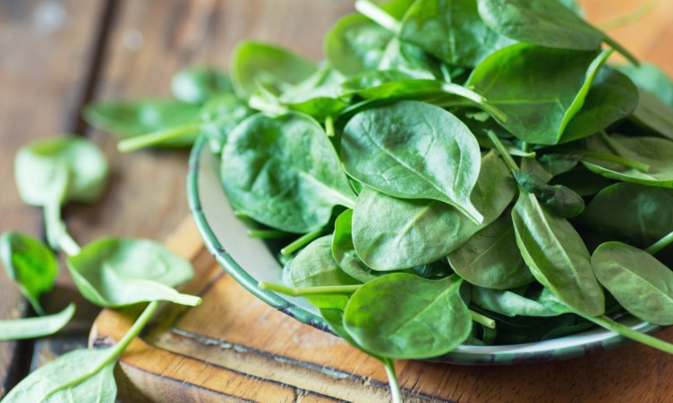 A bowl of spinach on a table