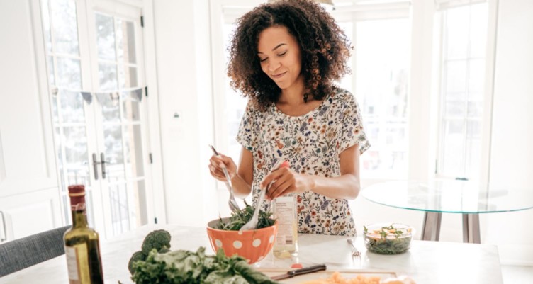 woman smiling making salad