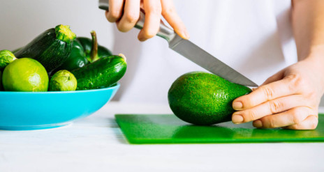 Persoon die avocado in plakjes snijdt