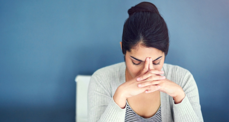 Woman with fingertips on brow