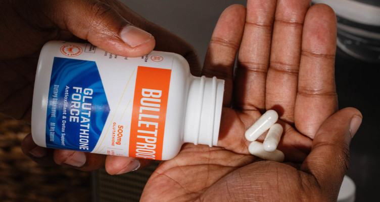 A hand spilling out a few capsules of Bulletproof Glutathione Force