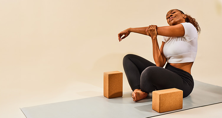 woman stretching with yoga blocks by her side
