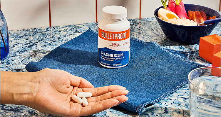 magnesium supplement in a bottle and some of the supplements in persons hand