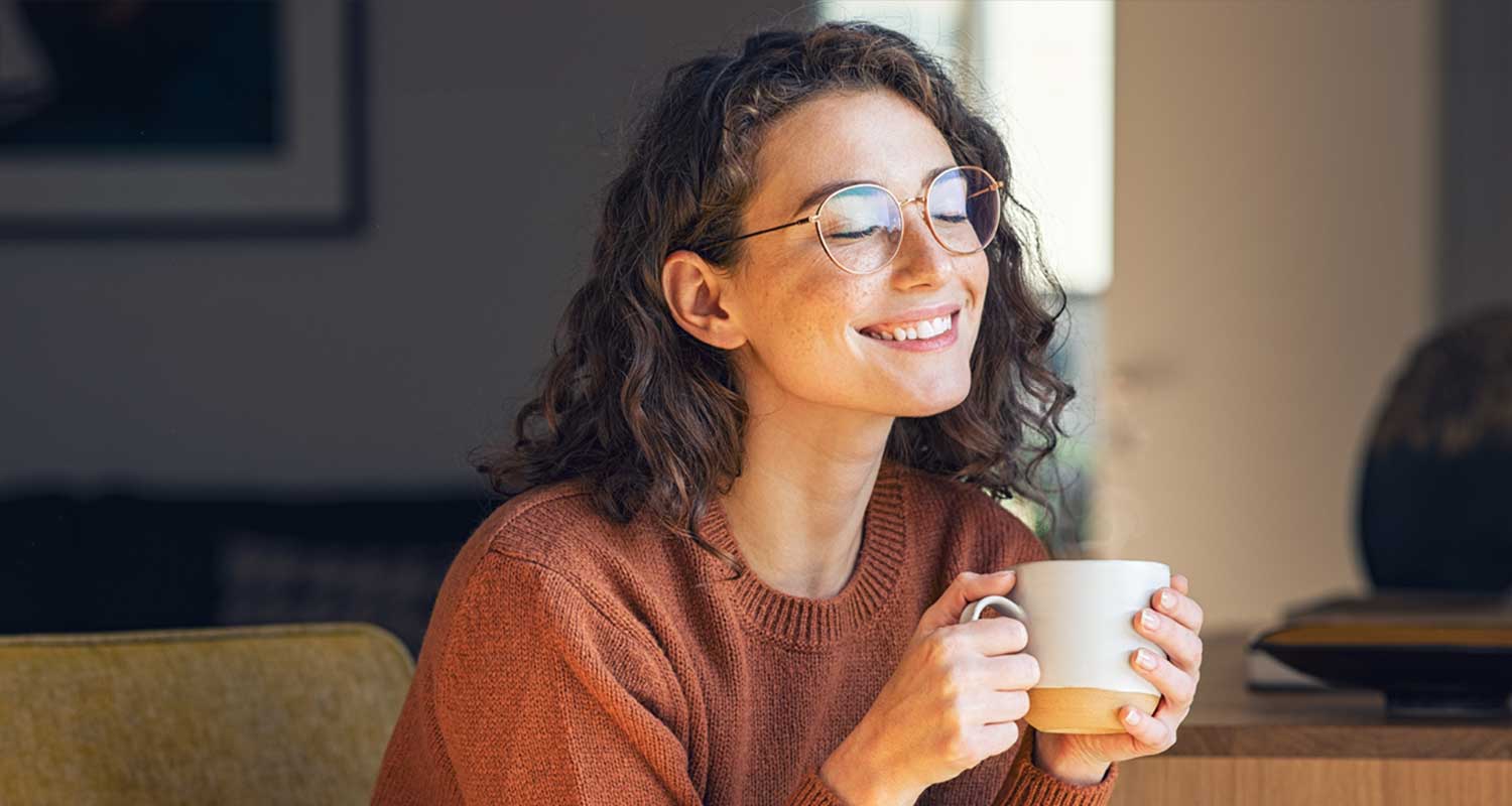 woman smiling and drinking coffee